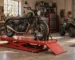Motorcycle secured on a service lift table with ATV parked in workshop — generated illustration